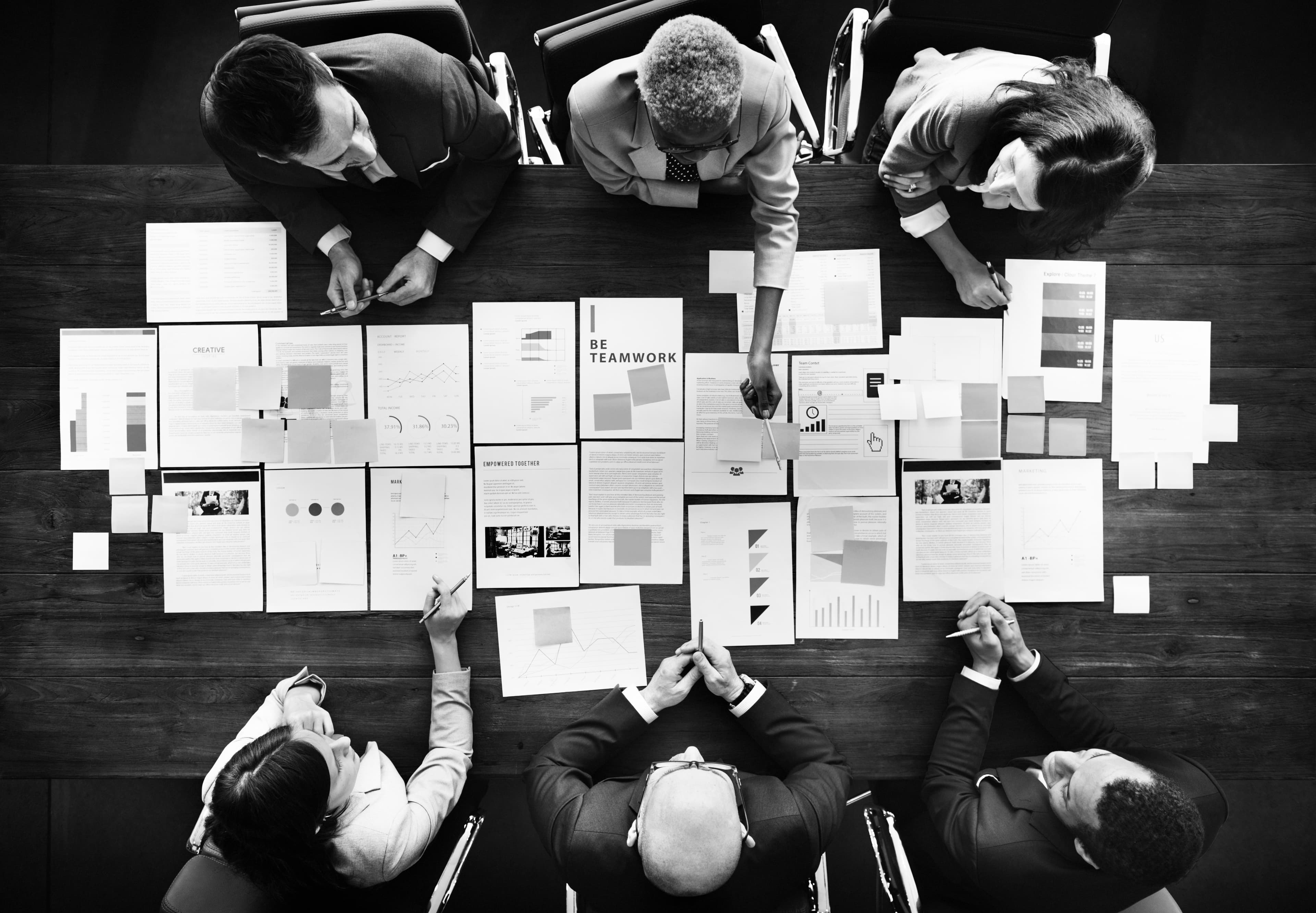 Team working together on project plans, overhead view