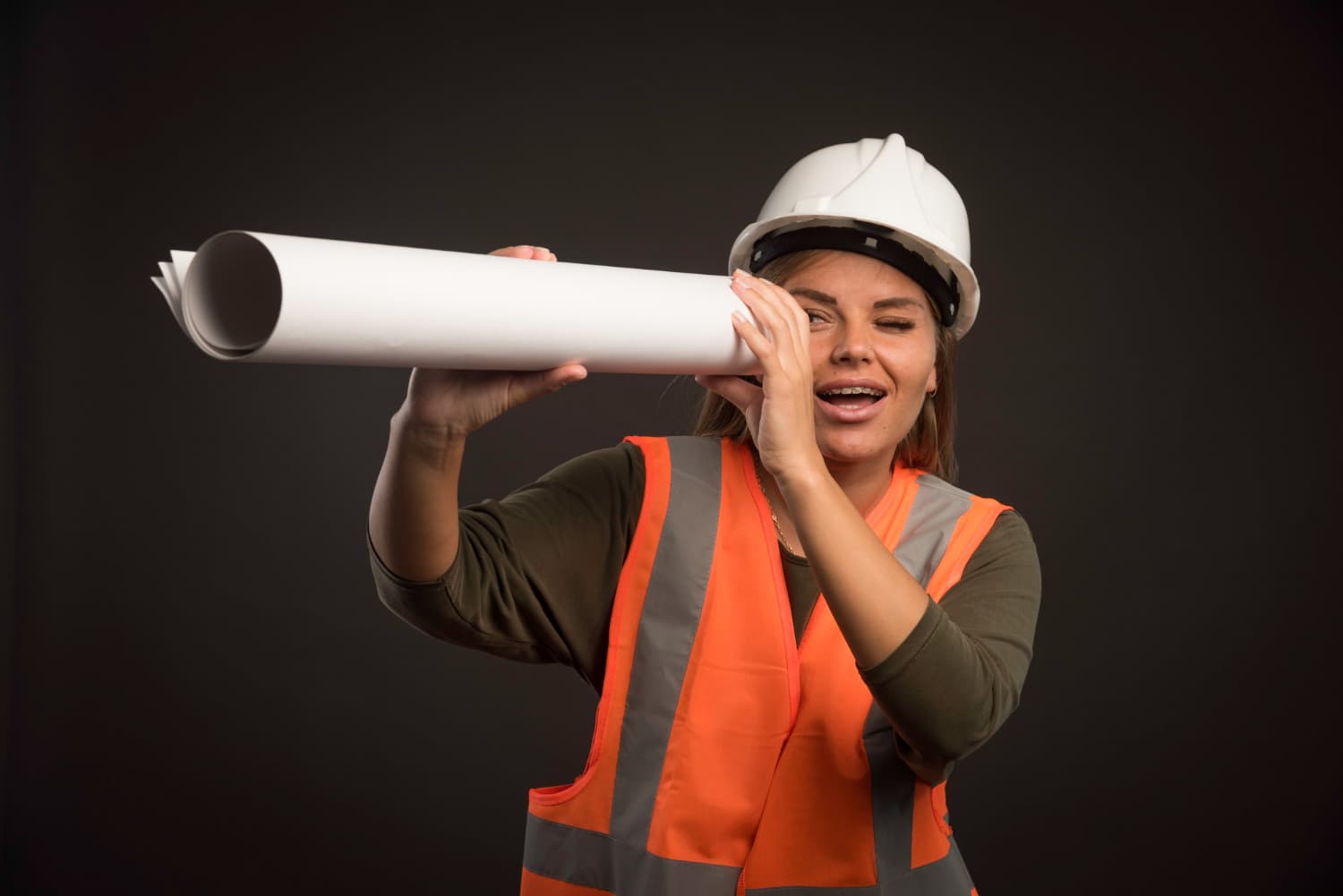 Construction worker looking through tube