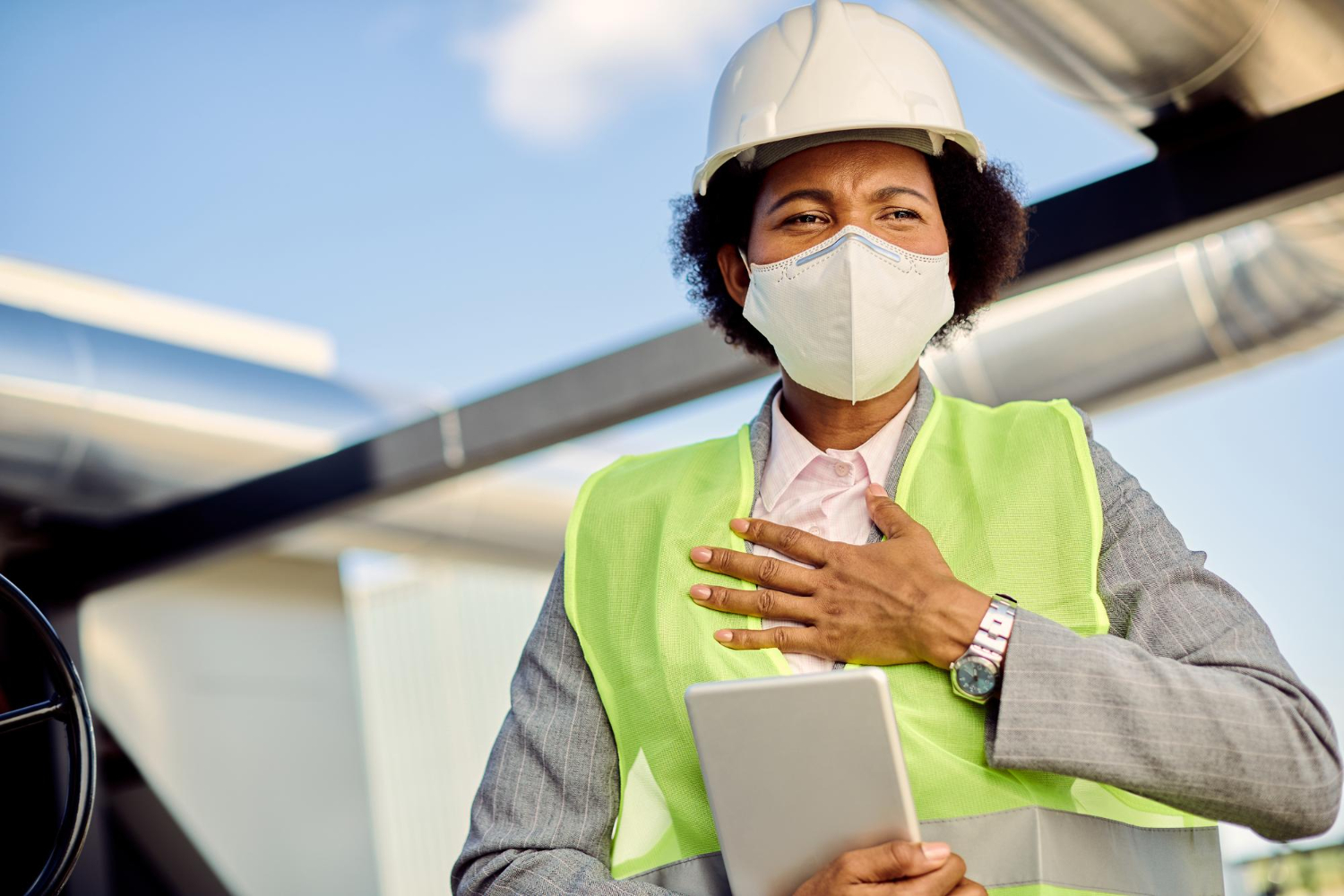 Construction professional wearing safety vest and mask